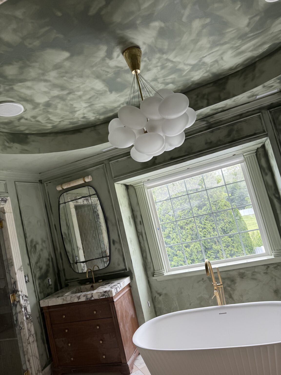 Bathroom walls and ceiling with a hand-applied, mottled green mineral finish